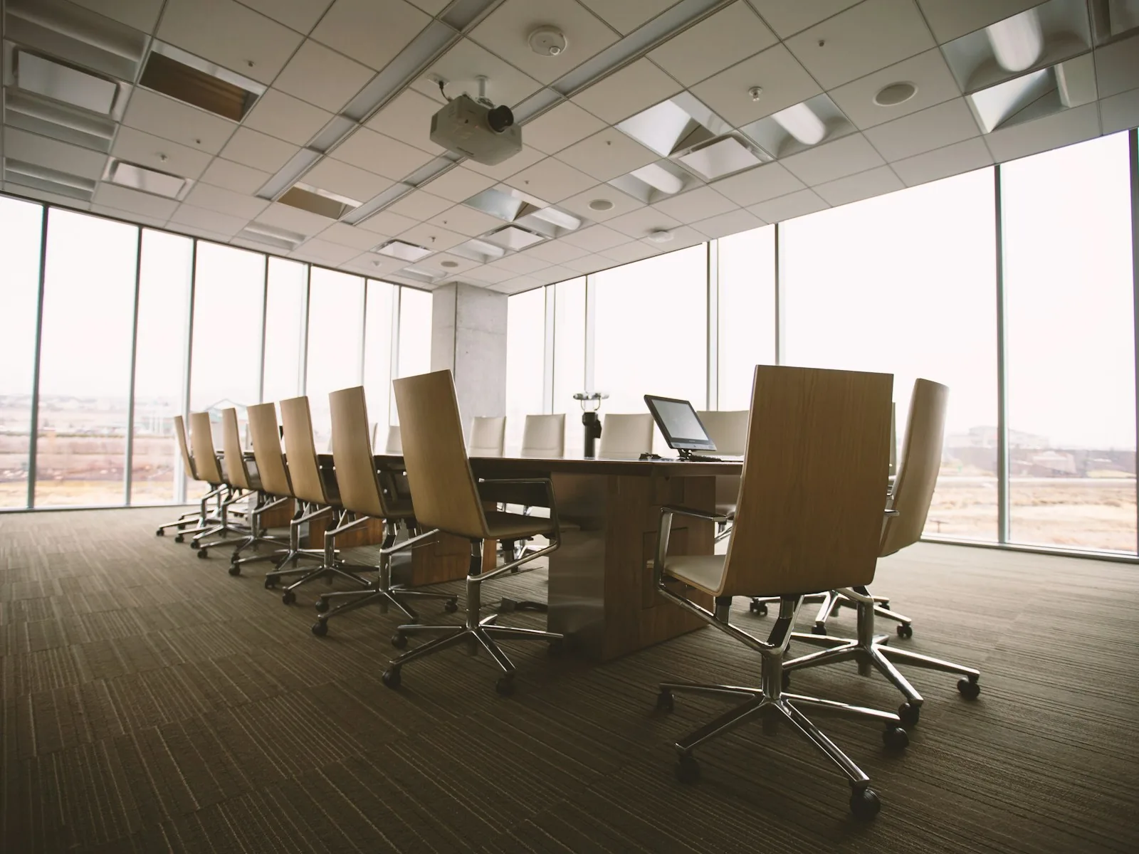 Meeting room with a long table and chairs beside floor-to-ceiling windows